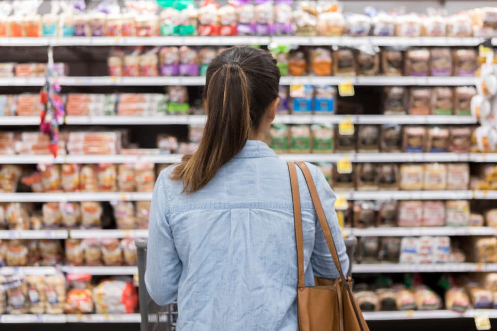 Unrecognizable Woman Marvels At Grocery Bread Selection