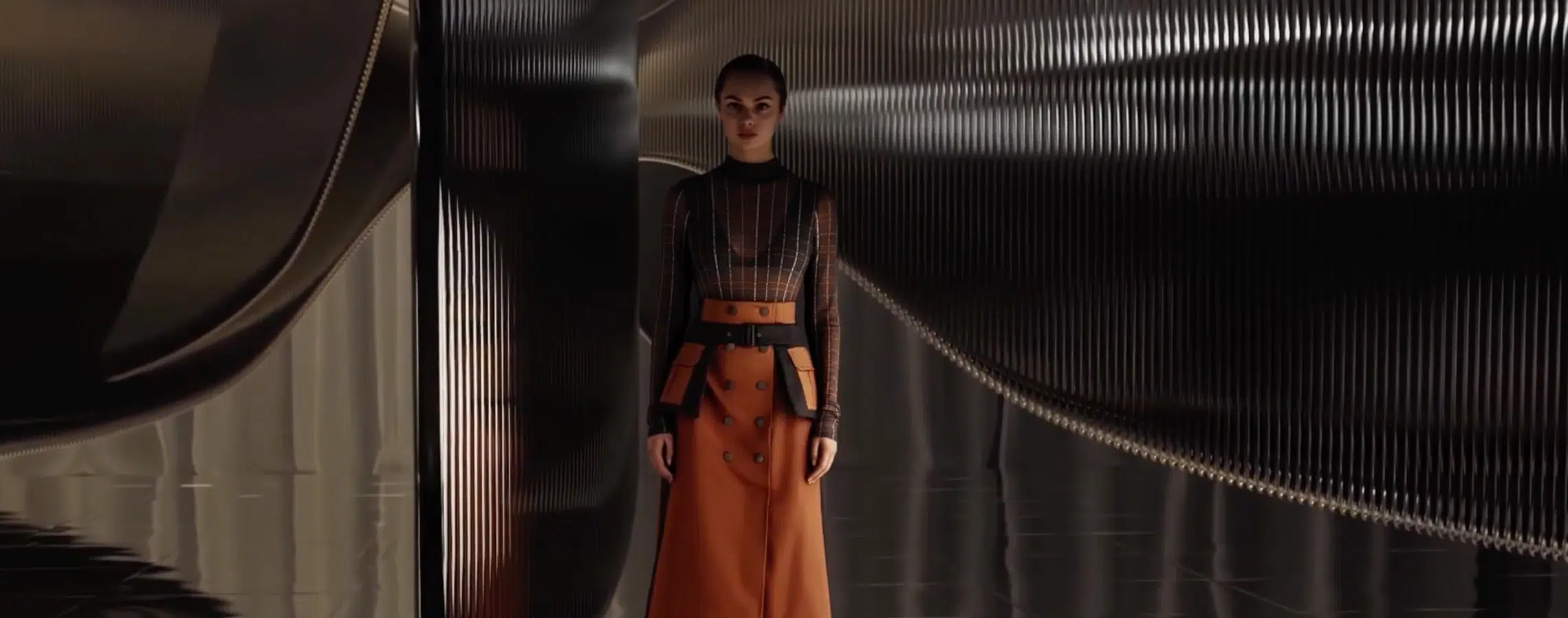 A person stands in a sleek modern hallway with ribbed reflective surfaces. Theyre wearing a black