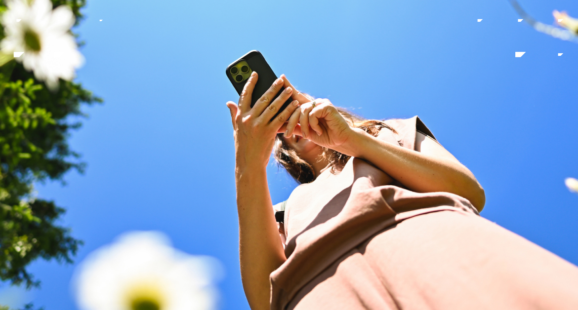 Young woman using a phone in nature.