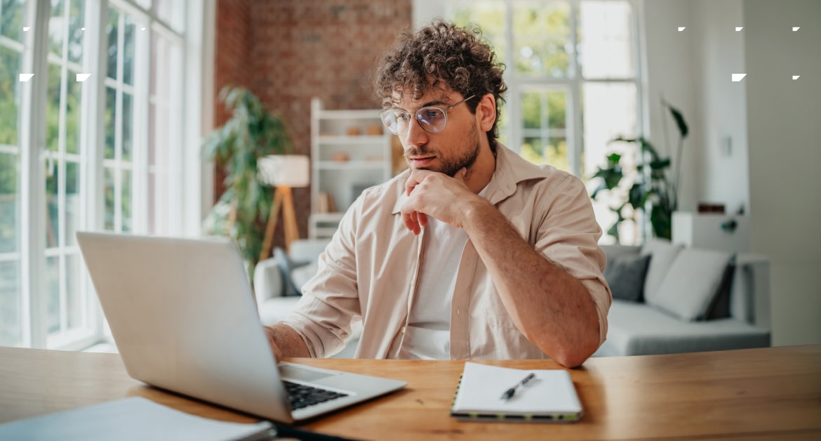 Email marketer looking at a laptop screen in a home office.
