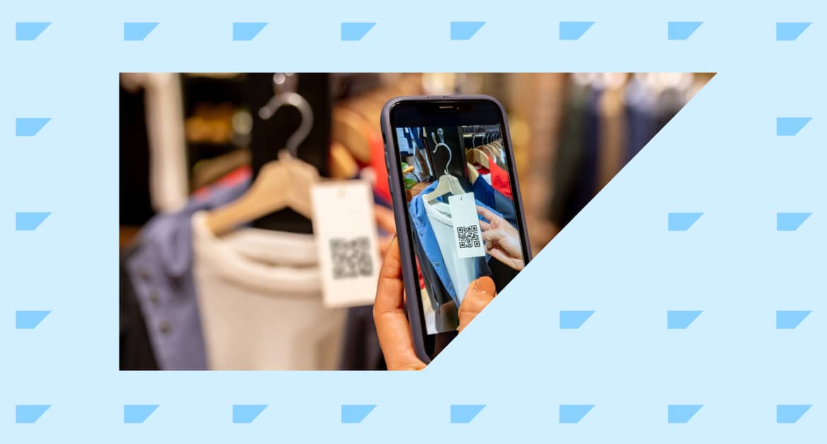 Shopper holding their phone and using a QR code on a clothing label in a retail store.