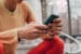 Person texting on a smartphone sitting outdoors in athletic wear with blurred trees in the background.