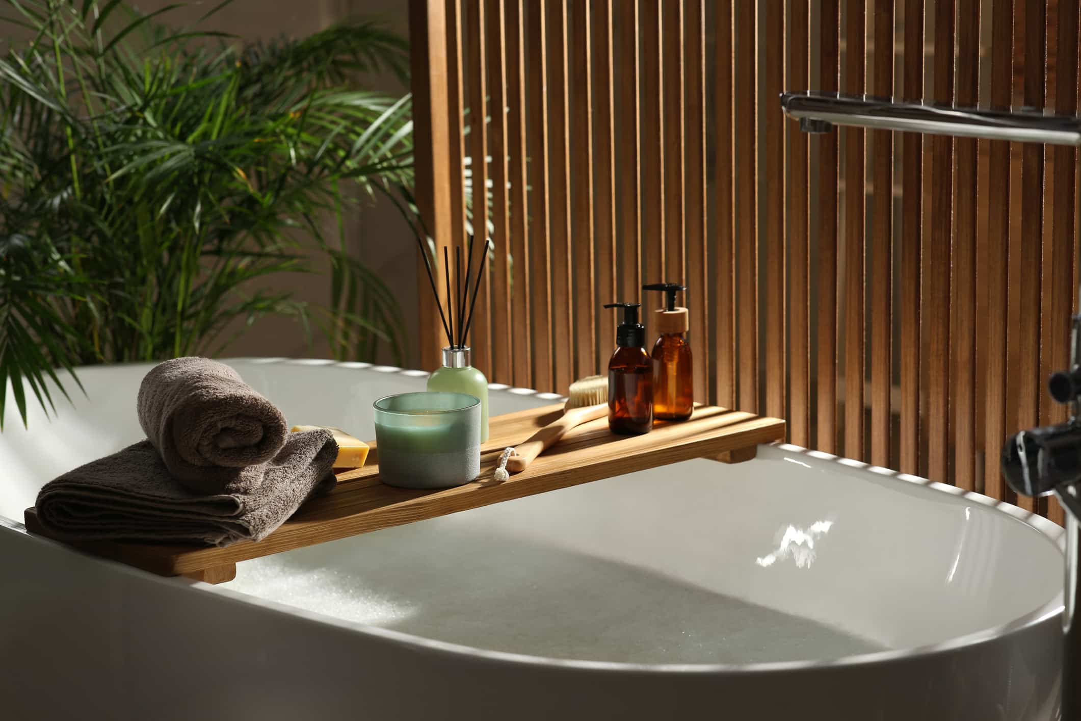 Wooden Bath Tray With Candle Air Freshener And Bathroom Amenities On Tub Indoors