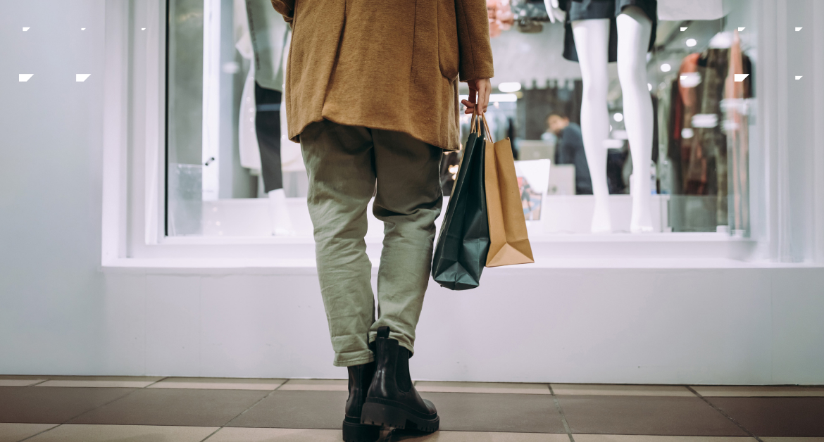 Person standing outside a clothing store window display