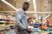 young male in a grocery store using phone to decide on a purchase