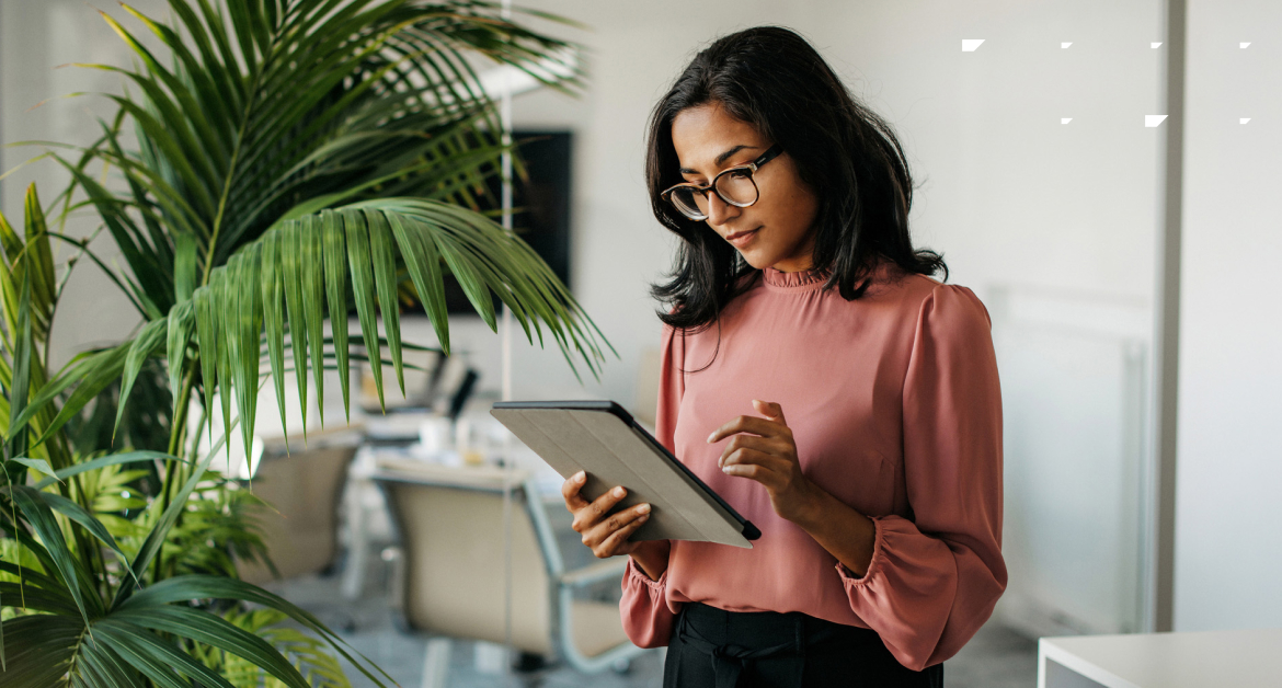 Marketing professional reviewing autonomous marketing campaign data on a tablet in a modern office