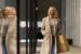 Female shopper in her 20s/30s walking in a mall in a winter coat.