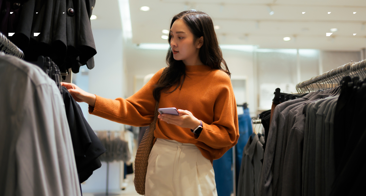 Millennial female customer browsing a fashion retail store.