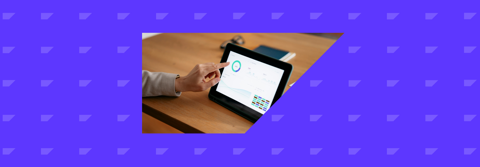 Marketer tapping a tablet screen on a desk showing a marketing automation workflow.