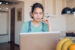 Young woman working or browsing on a laptop in her living room