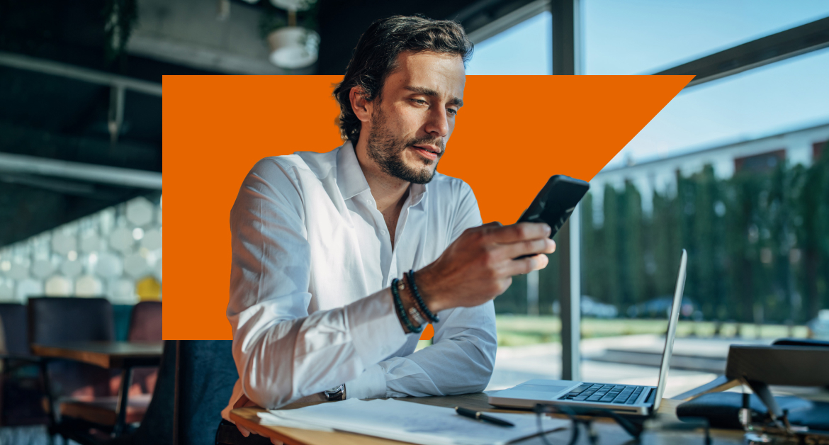 Male marketer checking his mobile at his desk
