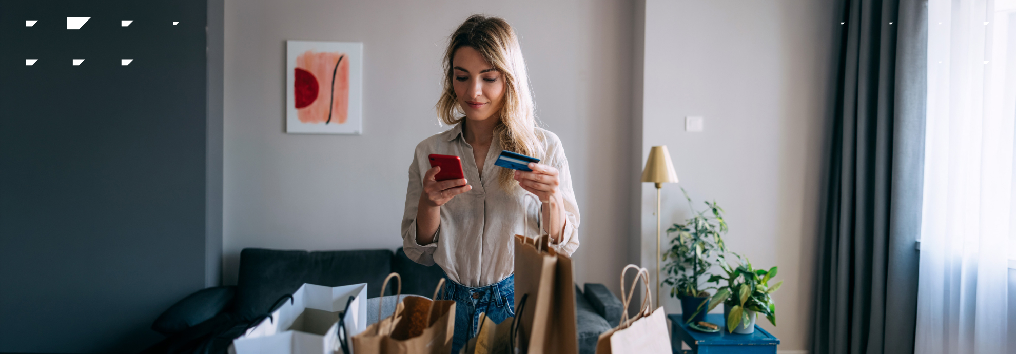 Young woman in her 20s using her credit card to buy something on her phone.